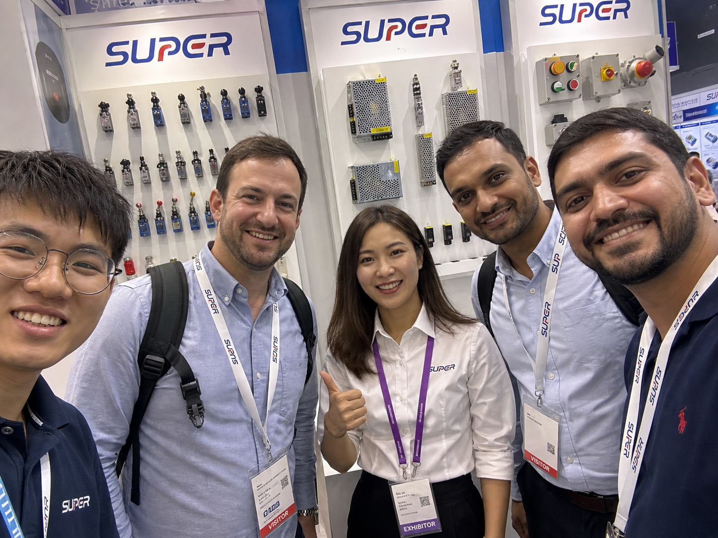 Candid group moment with international visitors at a SUPOR electrical exhibition booth